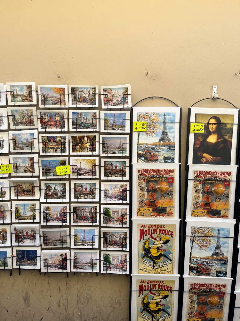 a display rack of posters and postcards with vintage style parisian prints