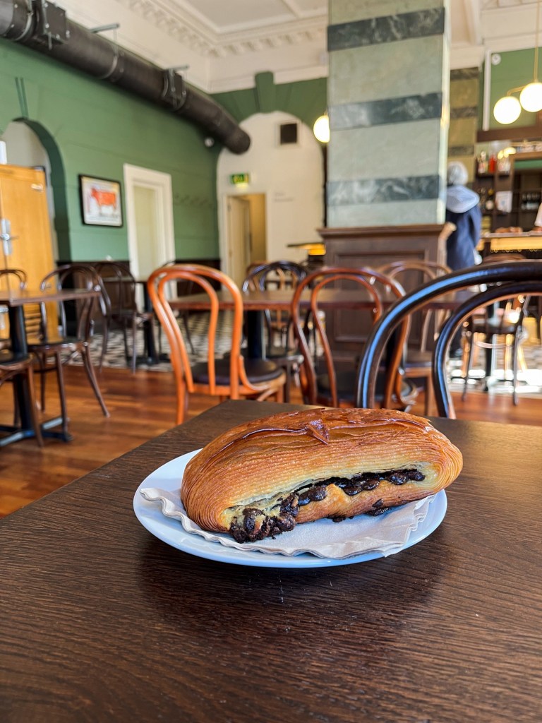 a pain suisse with chocolate oozing out of the side.