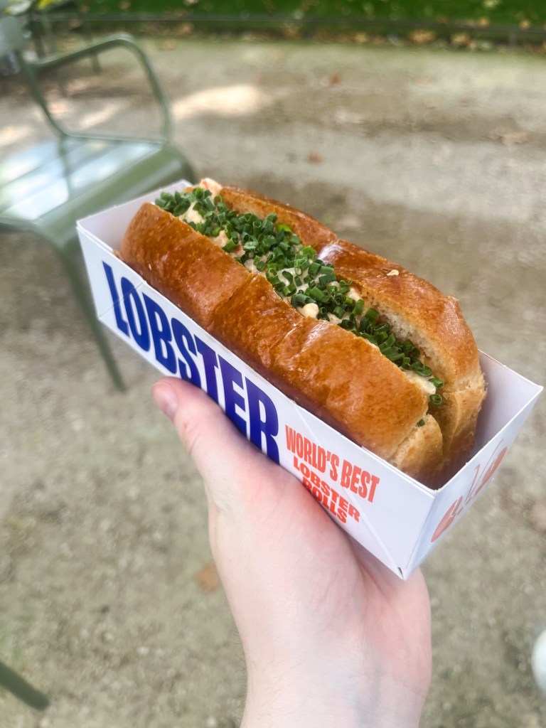 a crispy brioche sandwich with a lobster filling, topped with chives