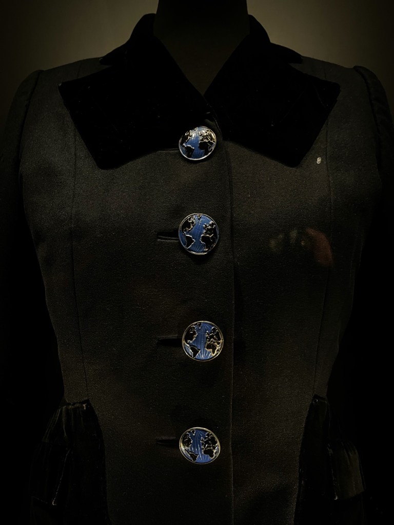 a black evening jacket with buttons shaped like the Earth