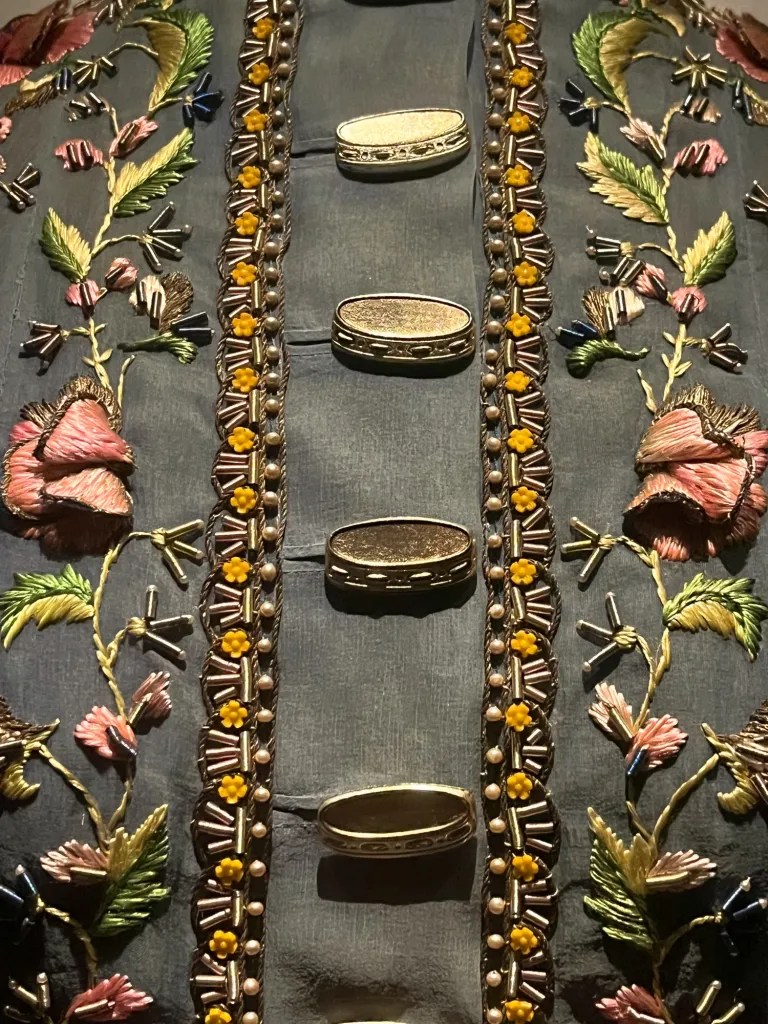 an embroidered jacket with buttons that look like tamborines