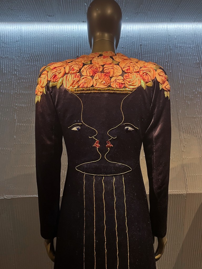 a long black coat with an optical illusion and roses on the back